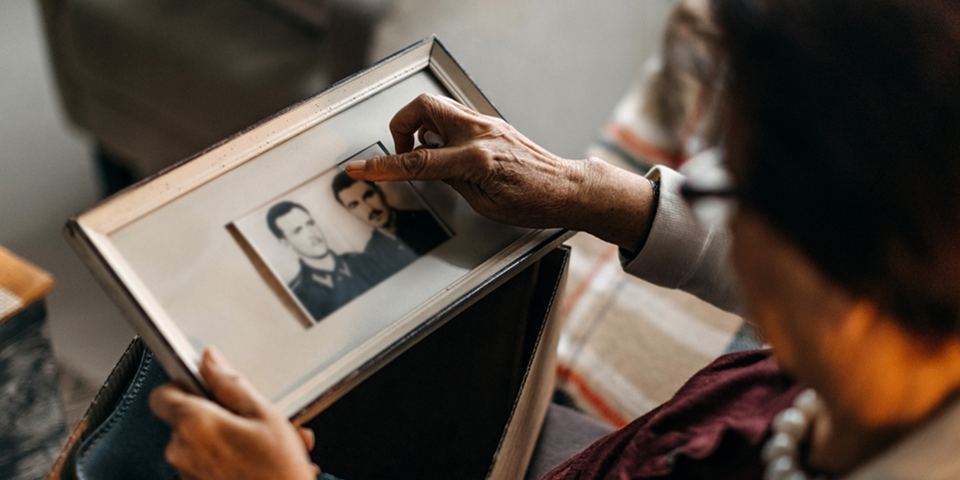 Older adult looking through framed vintage photographs