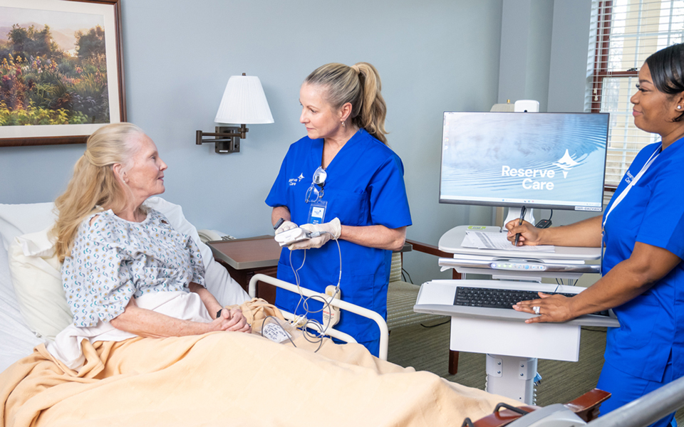 Hospice workers with patient with a computer