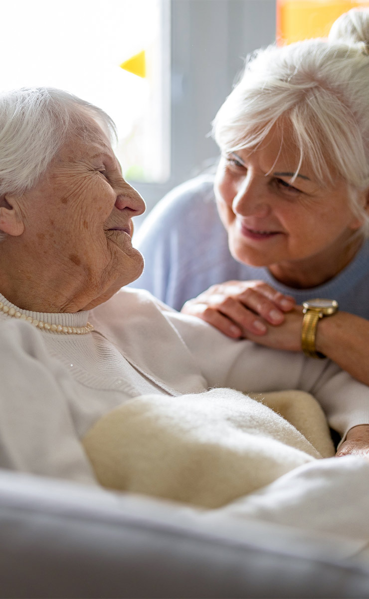 Family member providing comfort and companionship to an older loved one.