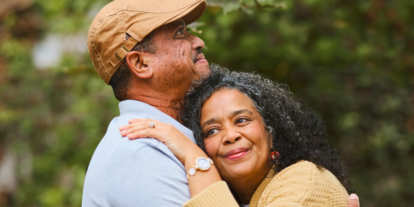 Older couple embracing affectionately outdoors