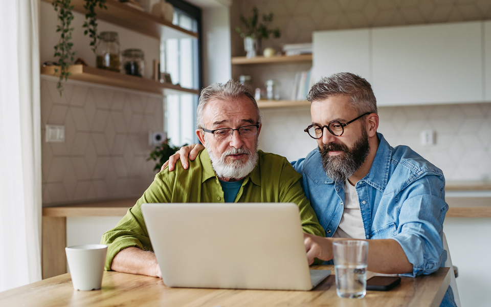 Men at table looking at laptop