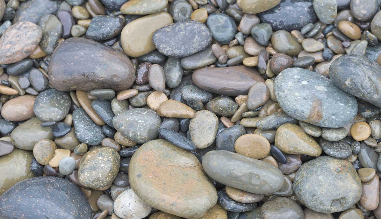 Smooth multicolored shoreline stones arranged in a natural pattern