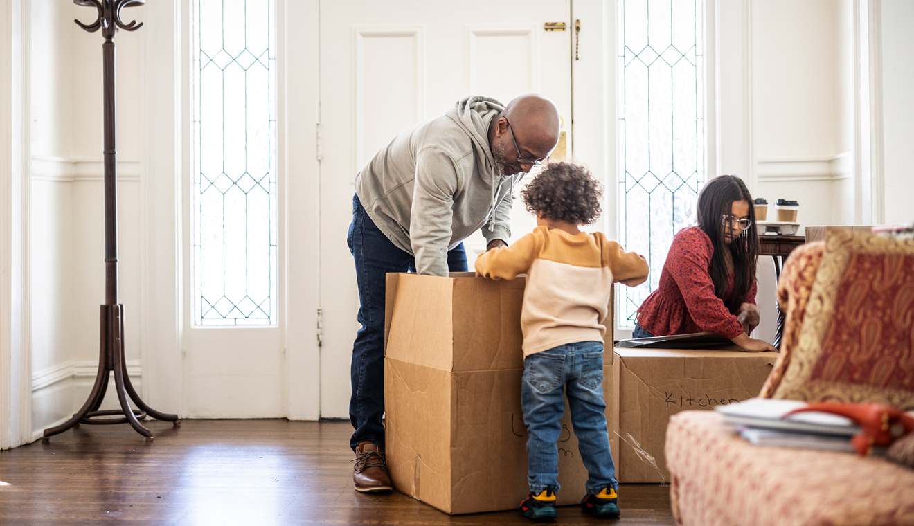 Family unpacking boxes together inside a home.