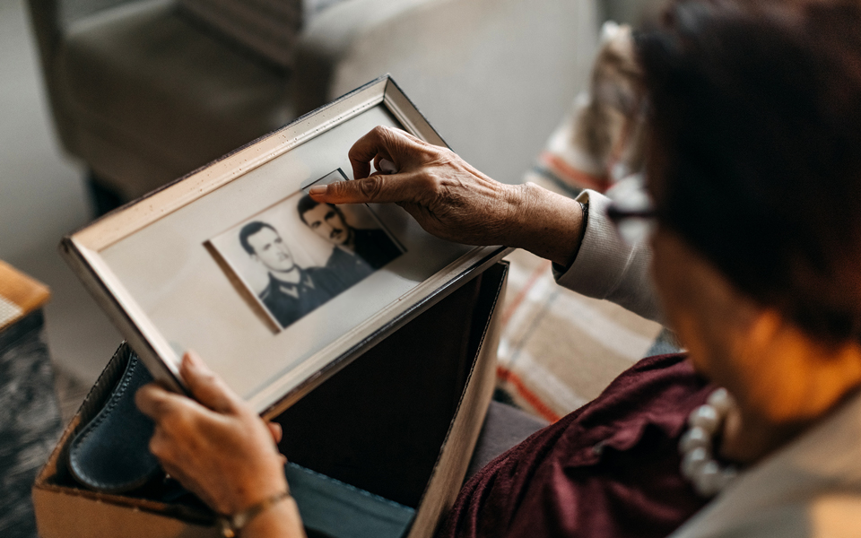 Older adult looking through framed vintage photographs